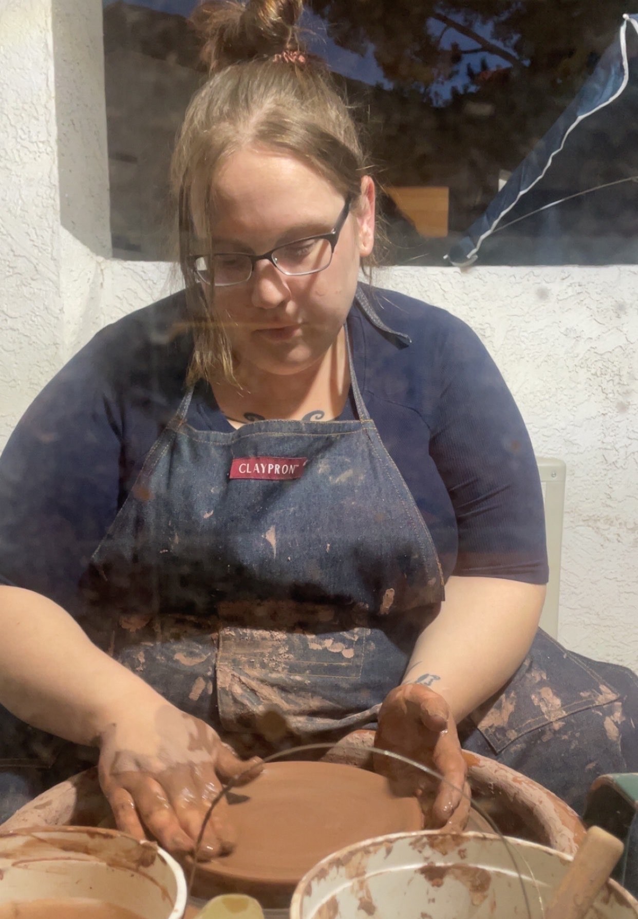 Shay throwing a ceramic plate